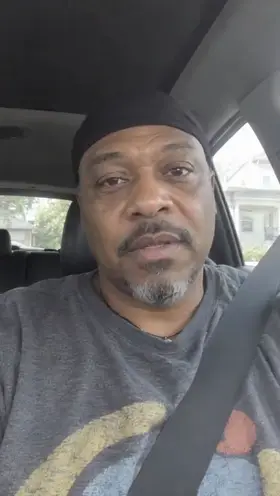 An actor sits in the driver's seat of a parked car with his seatbelt on and talks to the camera, an ad for a dash cam.